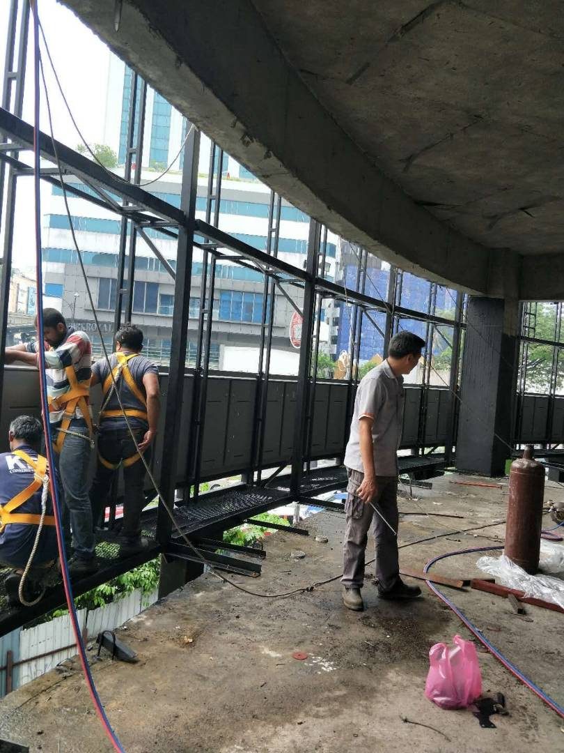 Quadniaga team installing LED display steel framework on site